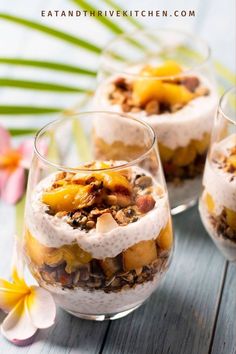 two glasses filled with dessert sitting on top of a table