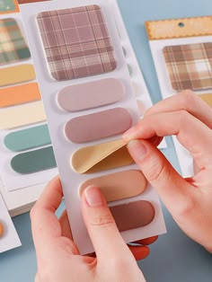 a person holding a palette in front of some color swatches on a blue surface