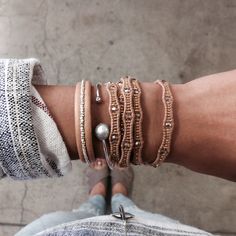 a person wearing several bracelets on their arm and one has a pearl in it