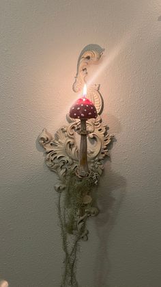 there is a candle that is lit on the wall next to a mushroom shaped light