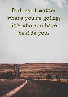 an empty road with the words it doesn't matter where you're going, it's who you have beside you