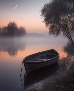 a boat sitting on top of a river next to a tree covered shore at sunset