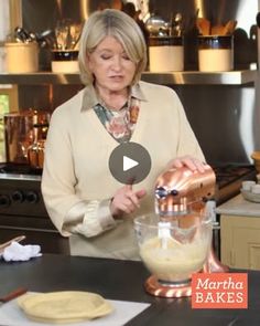 a woman pouring batter into a blender in a kitchen