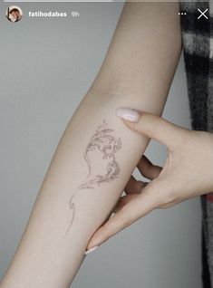 a woman's arm with a small tattoo on it