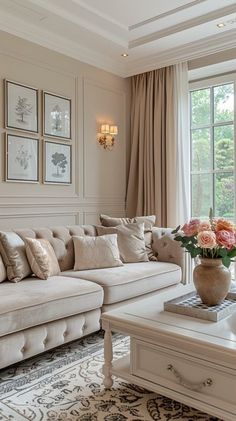 a living room filled with lots of furniture and flowers in a vase on top of a coffee table