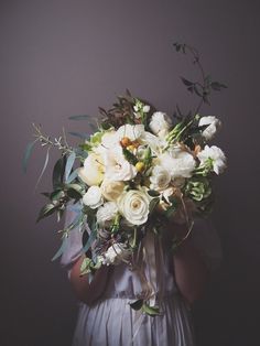 a woman holding a bouquet of flowers in her hands