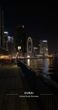 people walking along the waterfront at night in abu