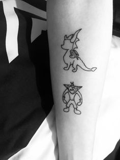 a person with a tattoo on their arm that has an image of pokemon and cat