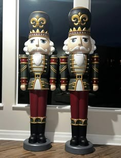 two nutcrackers are standing next to each other in front of a window