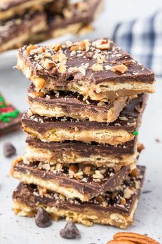 a stack of chocolate pecan bars on top of each other with nuts around the edges