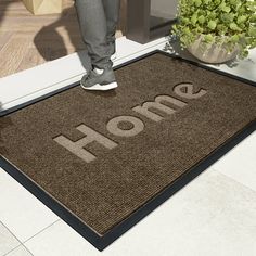 a person standing in front of a door with the word home on it and a potted plant