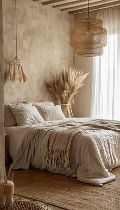 a bedroom with a large bed covered in white linens and two lamps hanging from the ceiling