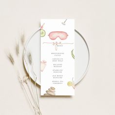 a white plate with a menu on it next to some dried flowers and a plant