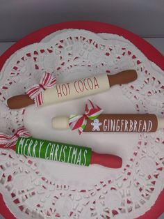 three christmas candy canes on a doily with the words hot cocoa and gingerbread