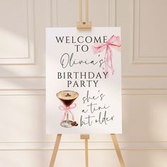 a welcome sign for a birthday party with a wine glass on the easel next to it