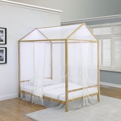 a bed with a white canopy and some pictures on the wall