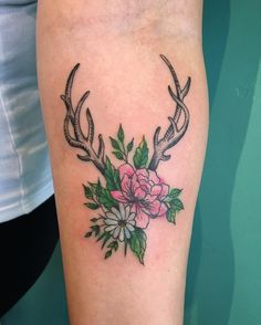 a tattoo with antlers and flowers on it