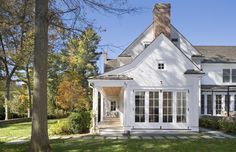 a large white house sitting on top of a lush green field