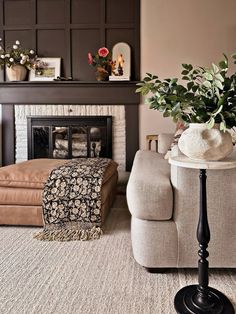 a living room filled with furniture and a fire place in front of a wall mounted fireplace