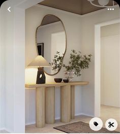 a room with a mirror, lamp and vases on the table in front of it