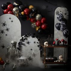 a halloween scene with balloons, skulls and spider webs on the wall in front of an arch