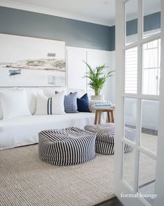 a living room filled with white furniture and pillows