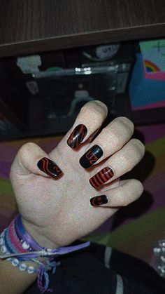 a woman's hand with black and orange designs on it