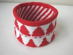 a red and white basket sitting on top of a table