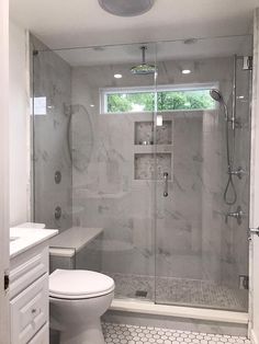 a white toilet sitting next to a walk in shower