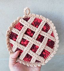 someone is holding up a crocheted dishcloth that looks like an ornament