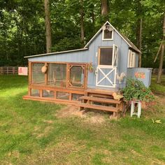 a blue chicken coop sitting on top of a lush green field