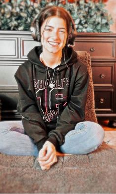 a young man sitting on the floor wearing headphones