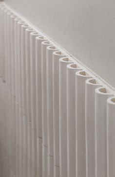 a row of white vases sitting next to each other on top of a wall