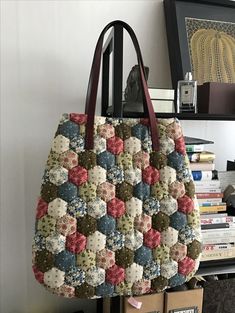 a handbag hanging up on a wall next to a book shelf and bookshelf