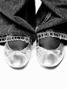 black and white photograph of someone's feet with jeans tied around them, wearing shoes