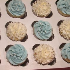 twelve cupcakes with blue and white frosting in a muffin box, ready to be eaten