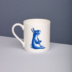 a blue and white coffee cup with a rabbit on it