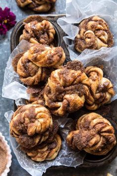 some cinnamon rolls are sitting on wax paper