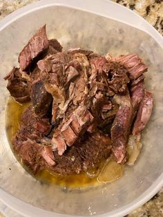 a bowl filled with sliced meat on top of a counter