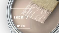 a paint can with a brush in it and the words artisan tea on it