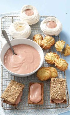 there is a bowl of peanut butter and some cookies on the cooling rack next to it