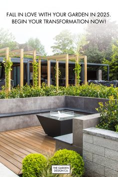 an outdoor garden with water fountain and wooden decking, surrounded by greenery in the foreground