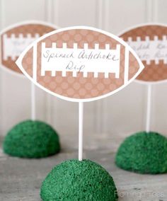 some green cake balls are sitting on top of each other, with a football sign in the middle