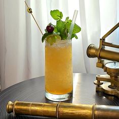 a tall glass filled with lemonade and garnish on top of a table