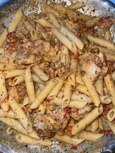 a pan filled with pasta and meat covered in sauce