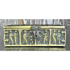 an antique metal box with figures on it