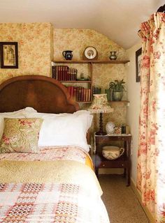 a bed sitting in a bedroom next to a window filled with curtains and books on top of a wooden headboard