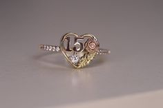 a heart shaped ring with the number 50 on it's side and flowers in the middle