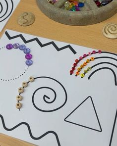 a child's art project that includes beads and letters, including an elephant face