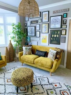 a living room filled with yellow couches and pictures on the wall next to a coffee table